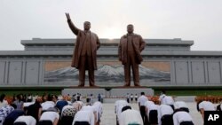 Pyongyang citizens visit Mansu Hill to pay homage to the bronze statues of President Kim Il Sung and Chairman Kim Jong Il ahead of the 27th anniversary of the death of President Kim Il Sung, in Pyongyang, North Korea, on July 7, 2021. 