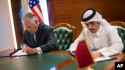 Menlu AS Rex Tillerson (kiri) dan menlu Qatar Sheikh Mohammed bin Abdulrahman Al Thani menandatangani nota kesepahaman di Doha, Qatar, 11 Juli 2017.