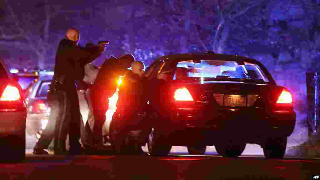 Police with guns drawn search for a suspect on April 19, 2013 in Watertown, Massachusetts.