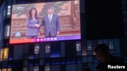 大屏幕播出的中国共产党总书记习近平与台湾主要在野党国民党主席郑丽文在北京人民大会堂会面时两人握手的画面。(2026年4月10日）