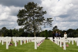 FILE - President Trump, first lady Melania Trump, French President Macron and Brigitte Macron, walk through The Normandy American Cemetery, following a ceremony to commemorate the 75th anniversary of D-Day, June 6, 2019, in Colleville-sur-Mer.