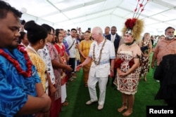 Raja Charles III disambut oleh para pelajar saat menghadiri peluncuran resmi Program Beasiswa Persemakmuran Raja di Universitas Nasional Samoa pada tanggal 24 Oktober 2024 di Apia, Samoa. (Foto: via Reuters)