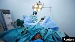 FILE - Doctors perform a fistula repair surgery on a patient in Maiduguri, Nigeria, July 31, 2018. Australian surgeon Dr. Andrew Browning has been performing similar procedures on women and girls in South Sudan.