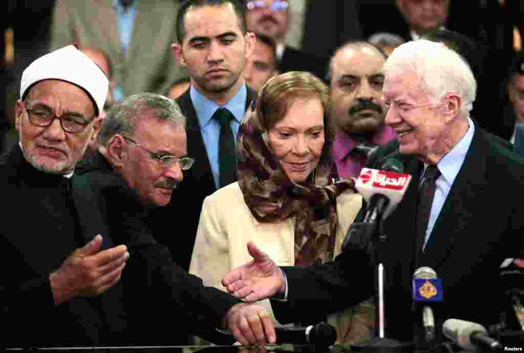 Former U.S. President Jimmy Carter shakes hands with an official from Al-Azhar in Cairo May 24, 2012. Carter is in Egypt as part of the mission of his Carter Center to monitor presidential elections.
