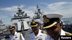 Indian navy personnel speak to the media onboard their Shivalik-class stealth multi-role frigate, INS Satpura