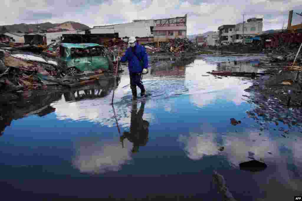 March 27: A man walks through a flooded street in the ravaged city of Kesennuma, northeastern Japan. (AP Photo/David Guttenfelder)