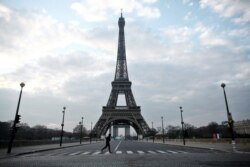 A man runs in front of the Eiffel Tower, in Paris, March 18, 2020.