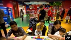 2017年12月23日，北京哈姆雷斯玩具店盛大开业时，带着孩子玩的中国家长。（资料照片）
