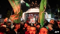 Kerumunan mengelilingi bus Palang Merah yang membawa tahanan Palestina yang dibebaskan dari penjara Israel dalam pertukaran sandera di Ramallah, Tepi Barat, 26 November 2023. (FADEL SENNA/AFP)