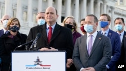 Problem Solvers Caucus co-chairs Rep. Tom Reed, R-N.Y., at podium, and Rep. Josh Gottheimer, D-N.J., right, speak to the media with members of their caucus about the expected passage of the emergency COVID-19 relief bill, Monday, Dec. 21, 2020, on…