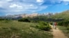 Hikers enjoy the Ute Trail, taking in the view of the alpine tundra and Never Summer Mountains.