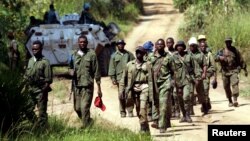 Des soldats des forces armées de la République démocratique du Congo (FARDC) patrouillent le village abandonné de Kaswara, à 60 km au sud-ouest de Bunia, dans la région de l'Ituri, dans l'est de la RDC, le 14 juillet 2006.