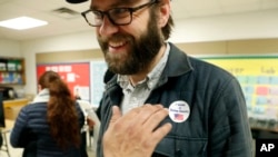 In this March 3, 2020 file photo, Democrat Jamie Wilson gets a sticker after voting in the Super Tuesday primary at John H. Reagan Elementary School in the Oak Cliff section of Dallas.