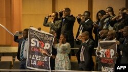 TOPSHOT - People hold a banners as they protest against the conflict in eastern Democratic Republic of Congo during the opening ceremony of the 37th Ordinary Session of the Assembly of the African Union at the AU headquarters in Addis Ababa on February 17, 2024.