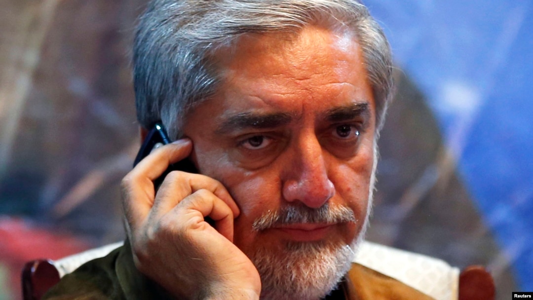 Afghan presidential candidate Abdullah Abdullah talks on his phone during an election campaign after a bomb attack on his convoy in Kabul, June 6, 2014.