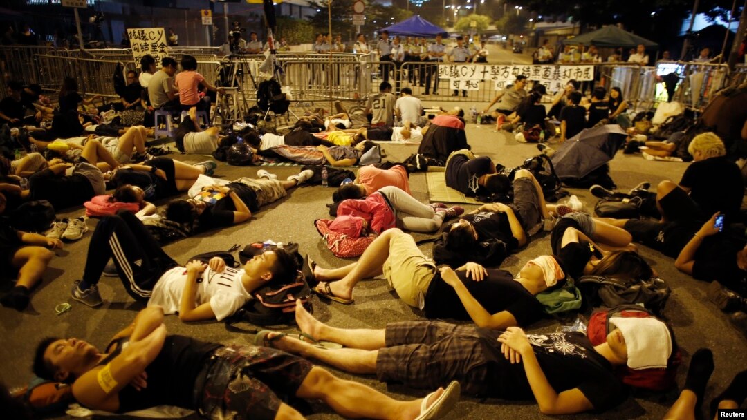 Para demonstran tidur di jalanan untuk memblokade jalan masuk ke kantor pemimpin Hong Kong Leung Chun-ying, Sabtu pagi (5/10).