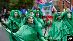 Climate protesters pass Brexit banners and flags outside Parliament in London, Britain, Oct. 8, 2019. 