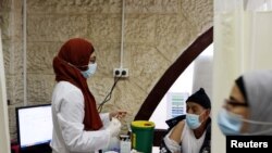 An Arab medical worker prepares to vaccinate a man against the coronavirus disease (COVID-19) as Israel continues its national vaccination campaign amid a third COVID-19 lockdown, in East Jerusalem, Jan. 7, 2021.