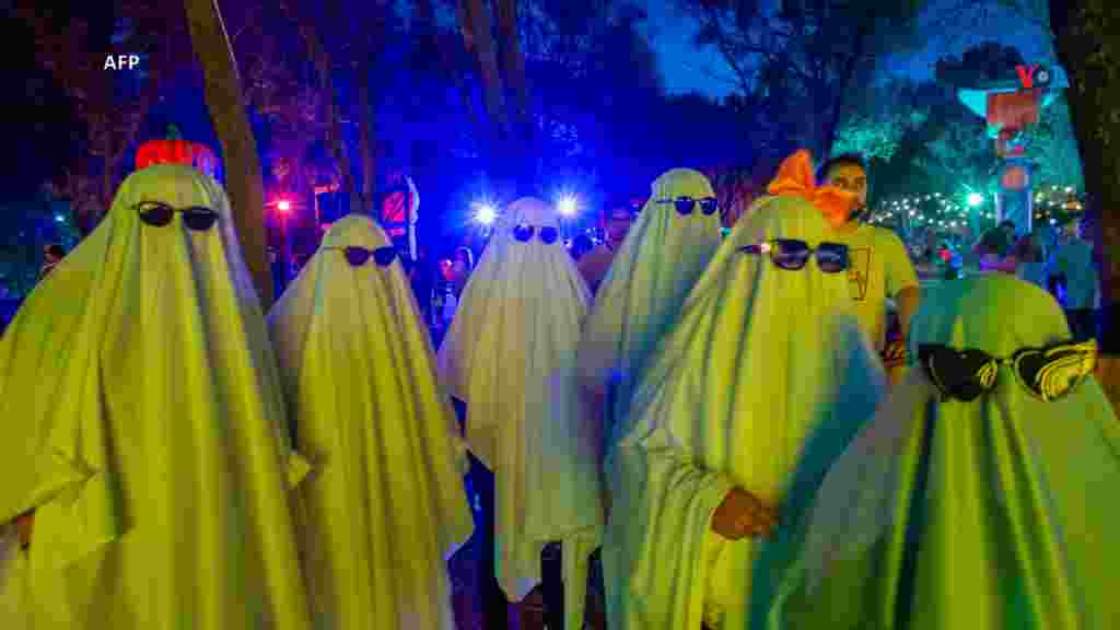 Personas disfrazadas de fantasmas disfrutan del Festival de la Calabaza en el Parque Fundidora antes de la celebración de Halloween en Monterrey, estado de Nuevo León, México.