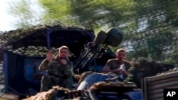 In this image taken from video released by the Russian Defense Ministry on Aug. 9, 2024, soldiers sit in a military truck as a column of the Russian Armed Forces move to build up forces fighting Ukrainian formations in the Sudzhansky district of Kursk region of Russia.