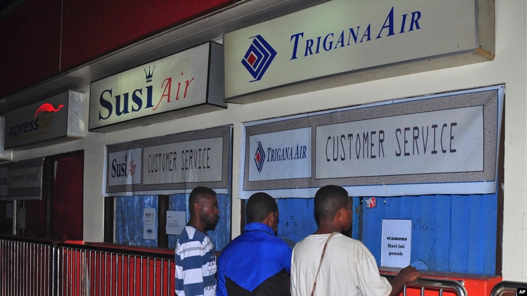 Keluarga penumpang pesawat Trigana Air yang hilang berdiri di depan loket Trigana Air yang tutup di bandara Sentani di Jayapura, Papua (16/8). 