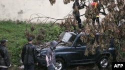 Des pompiers malgaches s'activent pour enlever un arbre tombé sur une voiture pendant le cyclone tropical Enawo à Antananarivo, Madagascar, le 8 mars 2017.