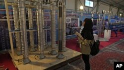 (FILE) A student looks at Iran's domestically built centrifuges in an exhibition of the country's nuclear achievements, in Tehran, Iran.