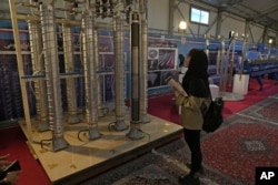 Seorang siswa melihat sentrifugal buatan dalam negeri Iran dalam pameran pencapaian nuklir negara itu, di Teheran, Iran, Rabu, 8 Februari 2023. (Foto: AP)
