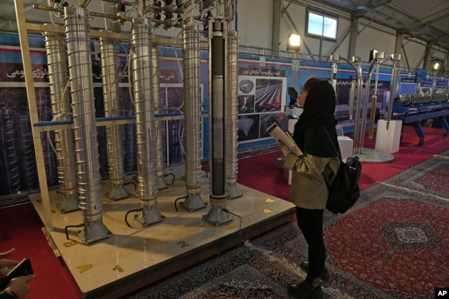 Seorang siswa melihat sentrifugal buatan dalam negeri Iran dalam pameran pencapaian nuklir negara itu, di Teheran, Iran, Rabu, 8 Februari 2023. (Foto: AP)