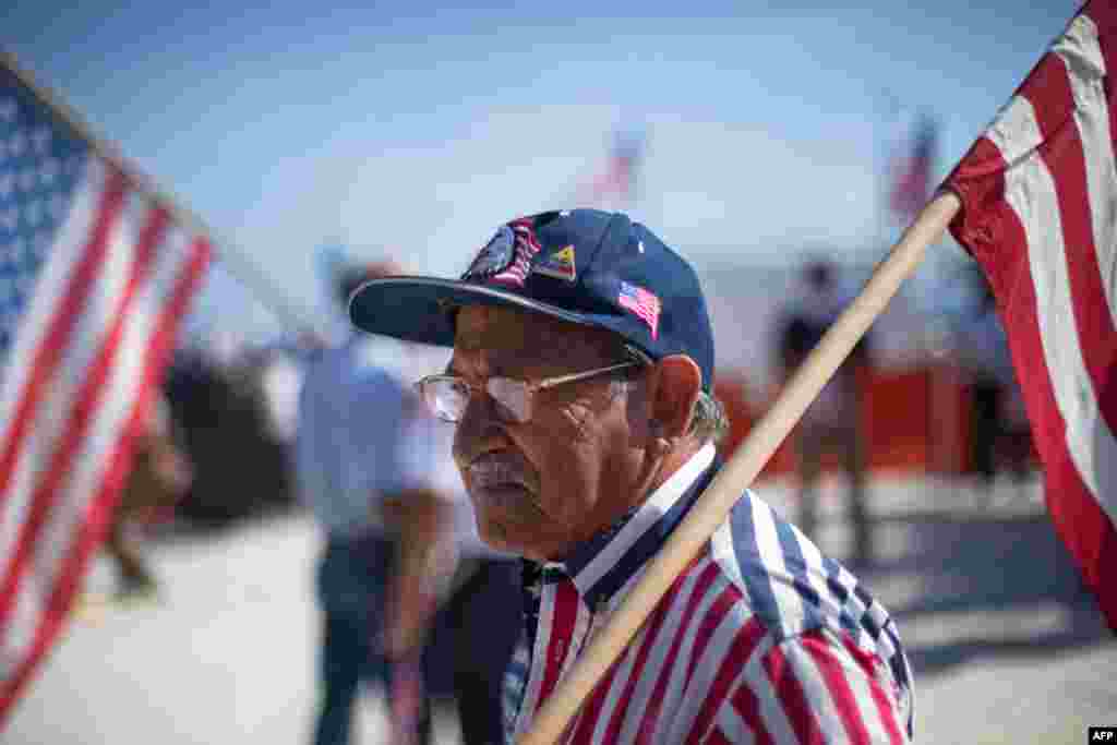 June 14: A man holds a U.S. flag before the arrival of President Barack Obama in San Juan, Puerto Rico. Obama's trip marks the first visit to Puerto Rico by a sitting U.S. President since John F. Kennedy's 1961 visit. (AP Photo/Ramon Espinosa)