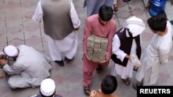 Seorang pegawai jasa penukaran uang tampak membawa sejumlah uang kertas di pasar pertukaran uang di Kabul, Afghanistan, pada 4 September 2021. (Foto: Reuters/Stringer)