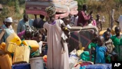 Des réfugiés fuient la violence au Soudan du Sud, traversent la frontière en Ouganda où ils attendent un moyen de transport pour la ville Koboko (en Ouganda), 6 janvier 2014.