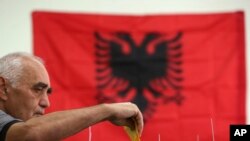 A man casts his ballot at a polling station in Tirana, June 30, 2019. 