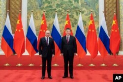 FILE - In this photo provided by China's Xinhua News Agency, Chinese President Xi Jinping, right, holds talks with Russian President Vladimir Putin at the Diaoyutai State Guesthouse in Beijing, China, Feb. 4, 2022.