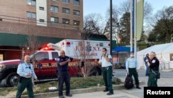 First responders outside of hard-hit Brooklyn Hospital Center take a bow as dozens of people in and around the New York City borough of Brooklyn's Fort Greene Park cheer and applaud them, New York, March 27, 2020.