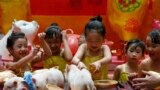 Girls play with live Teacup pigs, a rare pet in the country, at the start of celebrations leading to the Lunar New Year at Manila's Lucky Chinatown Plaza in Manila, Philippines, Feb. 1, 2019.