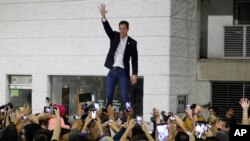 Opposition leader Juan Guaido waves to supporters during a rally at Bolivar Plaza in Chacao, Venezuela, Feb. 11, 2020. Guaido returned home from a tour of nations that back his effort to oust socialist leader Nicolas Maduro. 