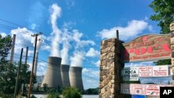 In this Aug. 23, 2018 photo, American Electric Power’s John Amos coal-fired plant in Winfield, W.Va., is seen from the town of Poca across the Kanawha River. 