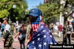 FILE PHOTO: A man dressed in an American flag joins protesters in Portland, Oregon, Aug. 31, 2020.
