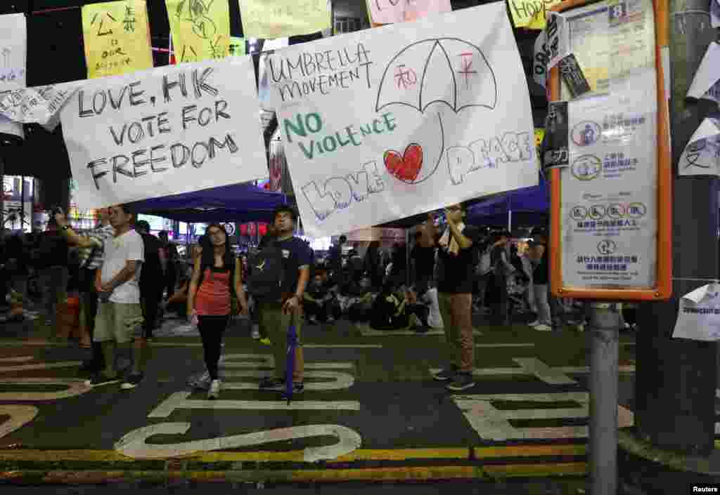 A poster with a drawing of an umbrella with the Chinese characters for "peace" is displayed at a rally as protesters block the main road at Causeway Bay shopping district in Hong Kong, Sept. 30, 2014. 