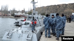 Ukrainian servicemen gather near the vessel Nikopol, one of three Ukraine's naval ships captured in the Kerch Strait and then returned by Russia, in the port of Ochakiv, Nov. 20, 2019.