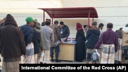 This photo released by the International Committee of the Red Cross shows its officials helping prisoners prepare to be freed by Yemen's Houthi rebels, in Sanaa, Yemen, Jan. 25, 2025.