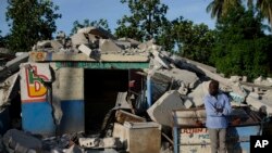 Un homme se tient devant un magasin effondré à Saint-Louis-du-Sud, Haïti, lundi 16 août 2021. 