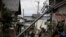 Residents walk along the mud-covered road in a neighborhood devastated by Typhoon Hagibis , Oct. 15, 2019, in Nagano, Japan.