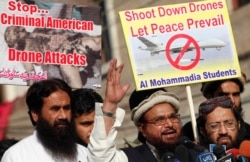 FILE - Hafiz Saeed, head of the Lashkar-e-Taiba group, second from right, addresses supporters during a protest against U.S. drone attacks in the Pakistani tribal region, in Lahore, Nov. 29, 2013.
