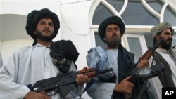 Former Taliban fighters stand in line as they surrender their weapons to Afghan authorities in Herat, west of Kabul, Afghanistan, 19 June, 2010.