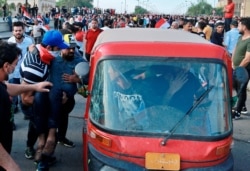 An injured protester is rushed to a hospital during a demonstration in central Baghdad, Oct. 25, 2019.