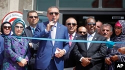 De gauche à droite, la Première Dame Emine Erdogan, le président Recep Tayyip Erdogan, le président Hassan Sheikh Mohamud de la Somalie et la Première Dame Qamar Ali Omar assistent à une cérémonie pour ouvrir une nouvelle ambassade turque à Mogadiscio, en Somalie, le vendredi 3 Juin, 2016. (AP Photo / Farah Abdi Warsameh)