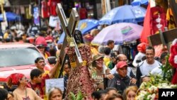 FILE - Catholic devotees carry a replica of the Black Nazarene during the blessing of replicas in front of the Quiapo church in Manila on January 4, 2024.