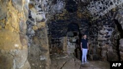 The conservation director of the town of Midyat Mervan Yavuz poses during an interview inside the Matiate archaeological site underneath the town in Midyat in Mardin province, southeastern Turkey, on July 1, 2024.